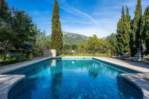 A rectangular swimming pool with a clear blue water surface, surrounded by a stone deck and a row of lounge chairs. - Chalet 'Villa Ca'n Tabou' with Mountain View, Private Pool and Wi-Fi (Selva)
