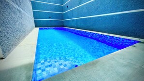 A swimming pool with blue mosaic tiles and a tiled floor. - RRR Luxury Villas (Cisarua)