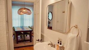 Un baño con un lavabo blanco, un espejo y un perchero para toallas.