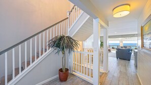 Un escalier avec des rampes blanches menant à un balcon d’où l’on peut admirer l’océan.