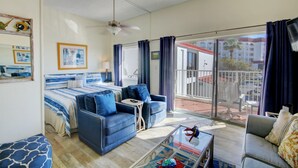 A spacious room with a bed, two sofas, a coffee table, and a balcony with a view. - El Matador 620 -  FREE TICKETS!! Your stay includes free tickets to many area attractions! (Fort Walton Beach)