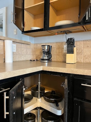 Une cuisine équipée d’une cuisinière intégrée, d’une machine à café et d’un bloc à couteaux.