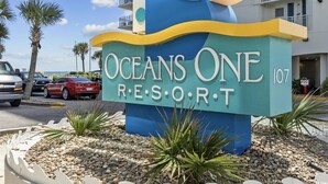 Une enseigne pour le complexe hôtelier Oceans One, au design moderne, avec un motif ondulatoire et le nom du complexe.
