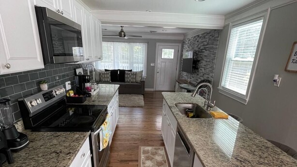A modern kitchen with white cabinetry, granite countertops, and a central island. -  4-bedroom house / 2 suite. Total 3 amazing  bathrooms Marietta with AC, WiFi (Marietta)