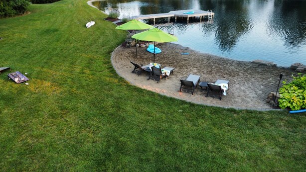 A lakeside patio with outdoor seating and umbrellas.