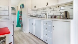 Una cocina moderna con armarios blancos, encimera roja y salpicadero de azulejos.