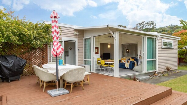 Una casa móvil con terraza, asientos exteriores y un patio cubierto.