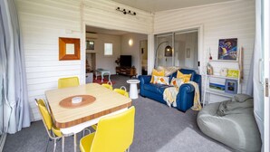 Un espacio habitable compacto con comedor, sofá y sillón de peluche.