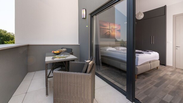 Quarto moderno com porta de vidro que dá para uma varanda.
