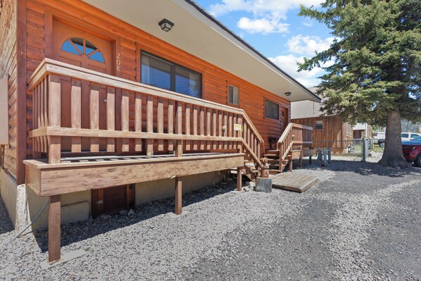 A wooden cabin with a wooden deck, a staircase, and a gravel driveway. - "Casa Del Rio Rojo 08" In Town-Cozy 1 Bedroom-Mountain Views-Pet Friendly (Red River)