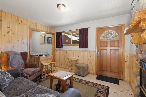 A cozy living room with a sofa, a small table, and a wooden dining area. - "Casa Del Rio Rojo 08" In Town-Cozy 1 Bedroom-Mountain Views-Pet Friendly (Red River)