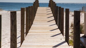 Ein Holzsteg, der zum Strand führt.