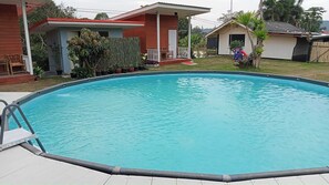 En rektangulär swimmingpool med en metallstege på vänster sida.