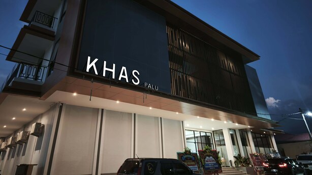 A modern building with a large sign reading "KHAS PALU". - Khas Palu Hotel  (Palu)