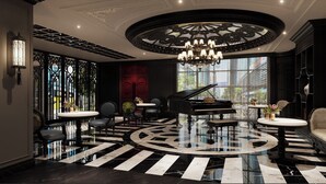 A grand lobby with a black and white checkered floor, a grand piano, and ornate wall decorations. - The Legend Hanoi Hotel (Hanoi)