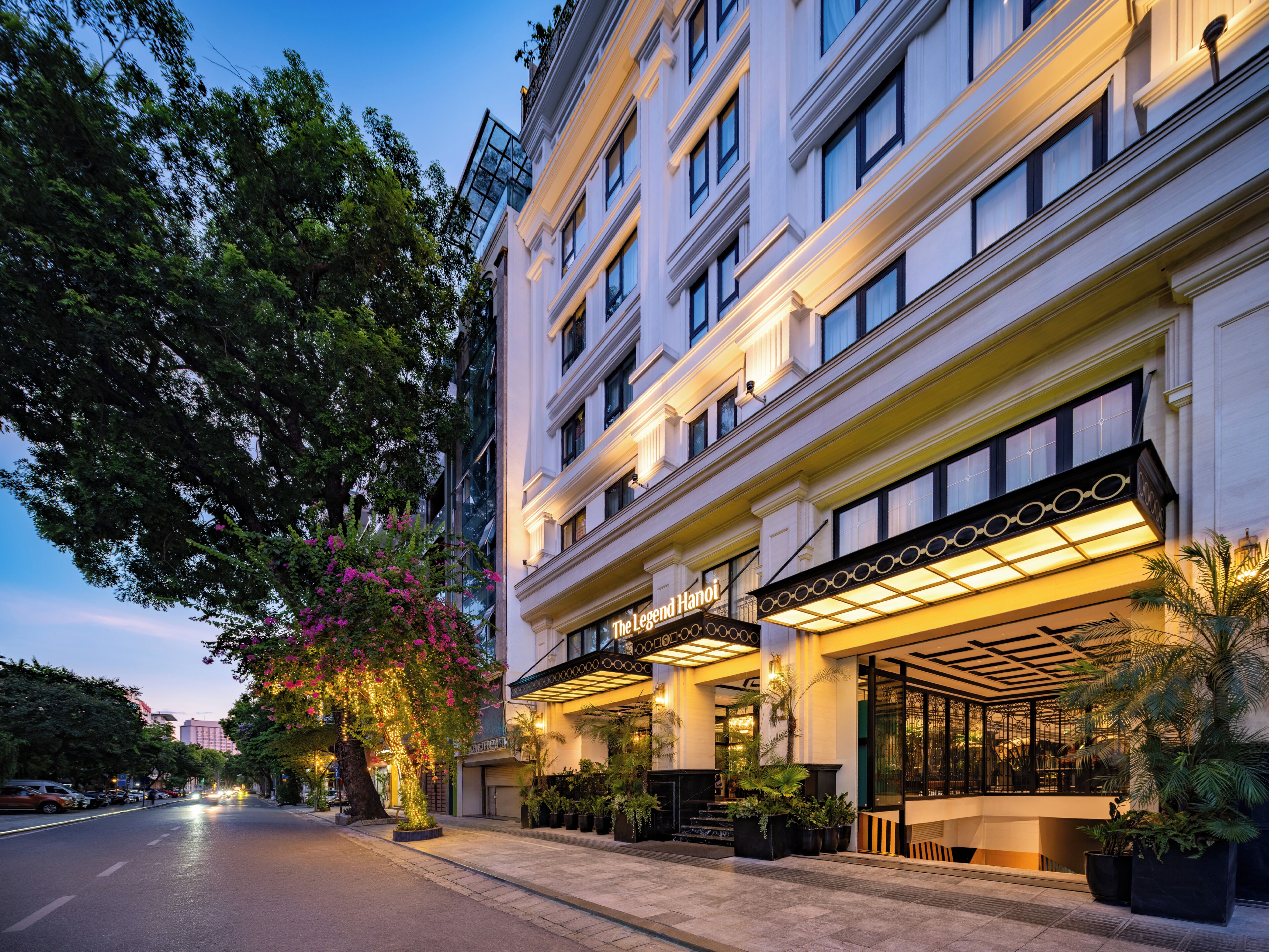 Un hotel con fachada clásica, varios pisos y una entrada bien iluminada.