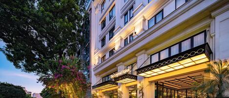 Un hotel con fachada clásica, varios pisos y una entrada bien iluminada.