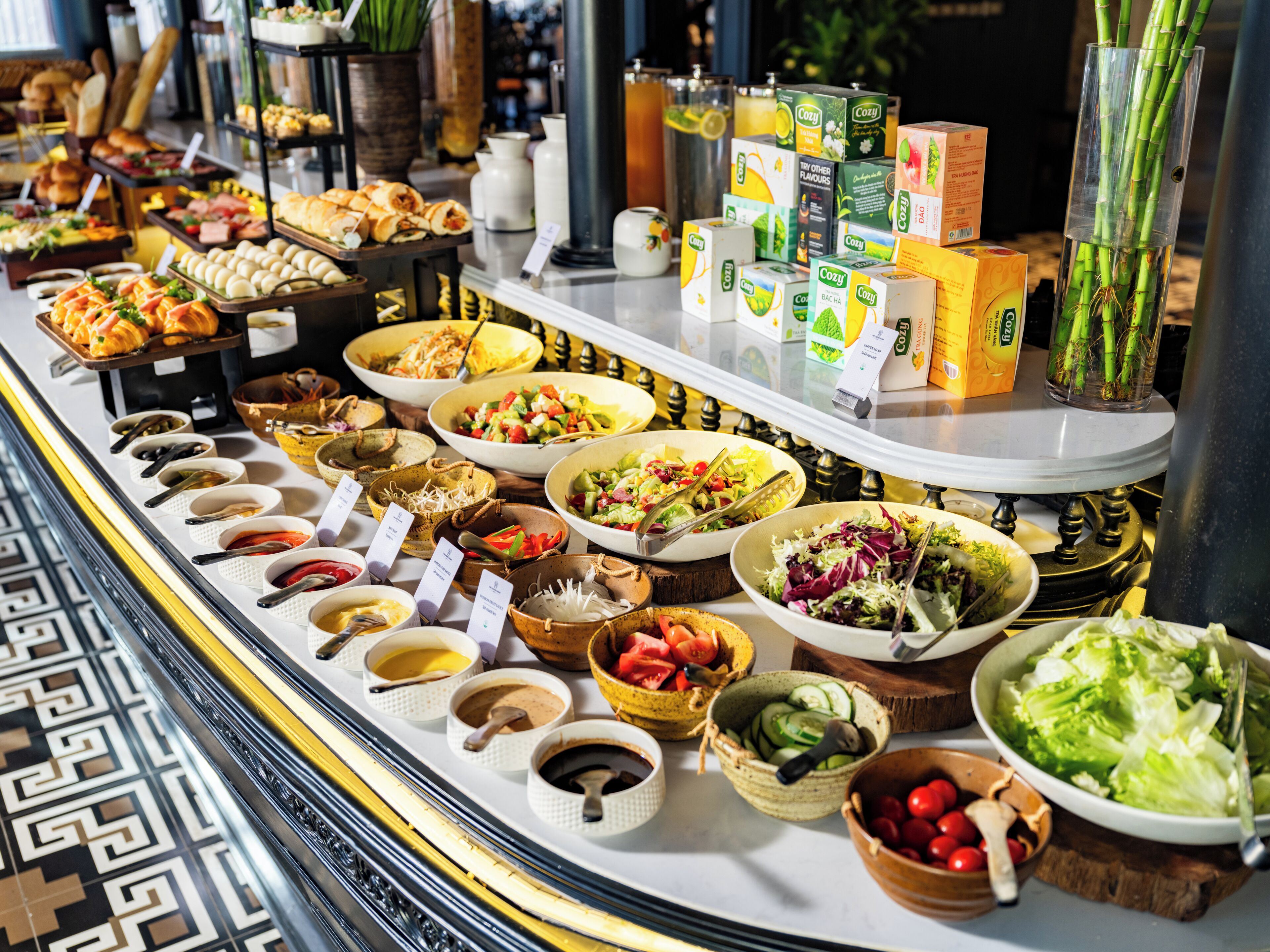 A buffet with various food items and beverages, including salads, soups, and boxed drinks.