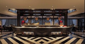 A reception area with a central counter, decorative columns, and a patterned floor. - The Legend Hanoi Hotel (Hanoi)