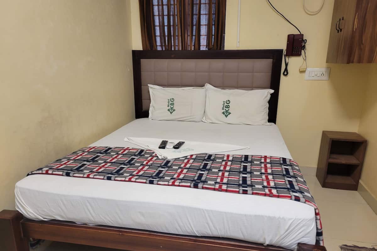 Una cama bien hecha con colcha escocesa, almohadas blancas y cabecera.