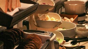 A buffet setup with various food items and serving utensils.