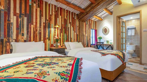 Une chambre avec deux lits, des murs recouverts de lambris en bois, un plafond en bois, une petite table avec une chaise, un miroir et une salle de bain avec des toilettes et un lavabo.