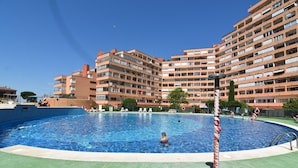 Une piscine entourée d’immeubles résidentiels à plusieurs étages.