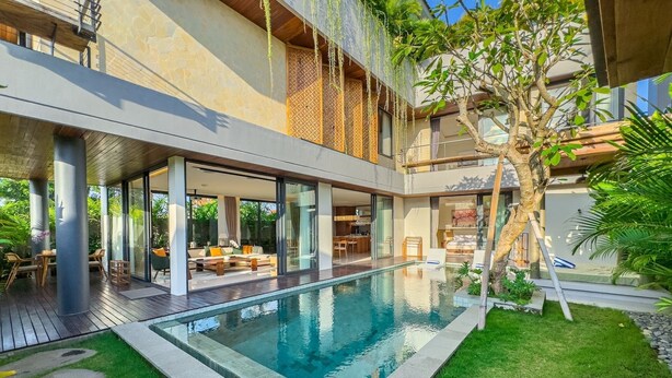 A modern house with a swimming pool, outdoor seating, and a large tree. - Narawangsa Villa | 4br | Rooftop West Coast View (Kerobokan)
