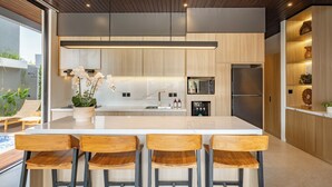 A modern kitchen with a large island, bar stools, and built-in appliances. - Private Villa Ayra 9B 10min Melasti Beach (Ungasan)