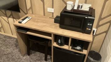 A compact kitchenette with a microwave, coffee maker, and a small refrigerator.