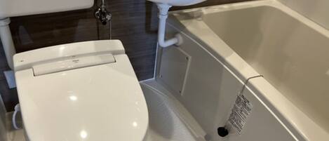 A bathroom with a toilet, sink, and bathtub.
