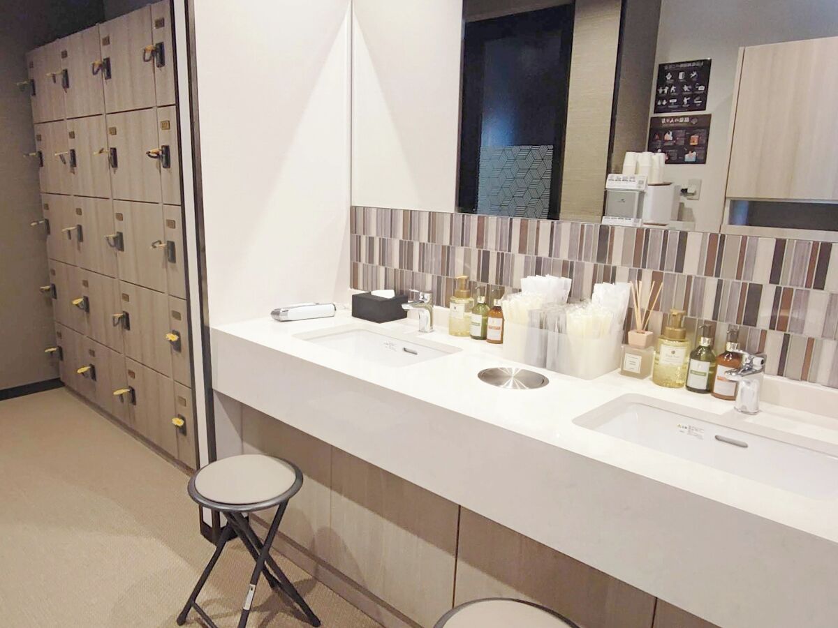A modern bathroom with two sinks, a mirror, and a storage cabinet with multiple drawers.