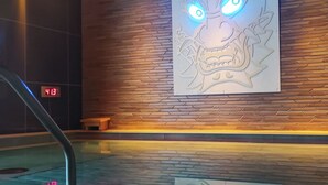 Un área de spa con una pared de madera, un reloj digital y un mural decorativo con un dragón.