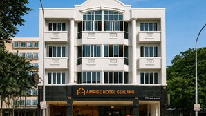 Un hôtel moderne doté d’une entrée imposante, de nombreux balcons et offrant une vue dégagée sur la rue.