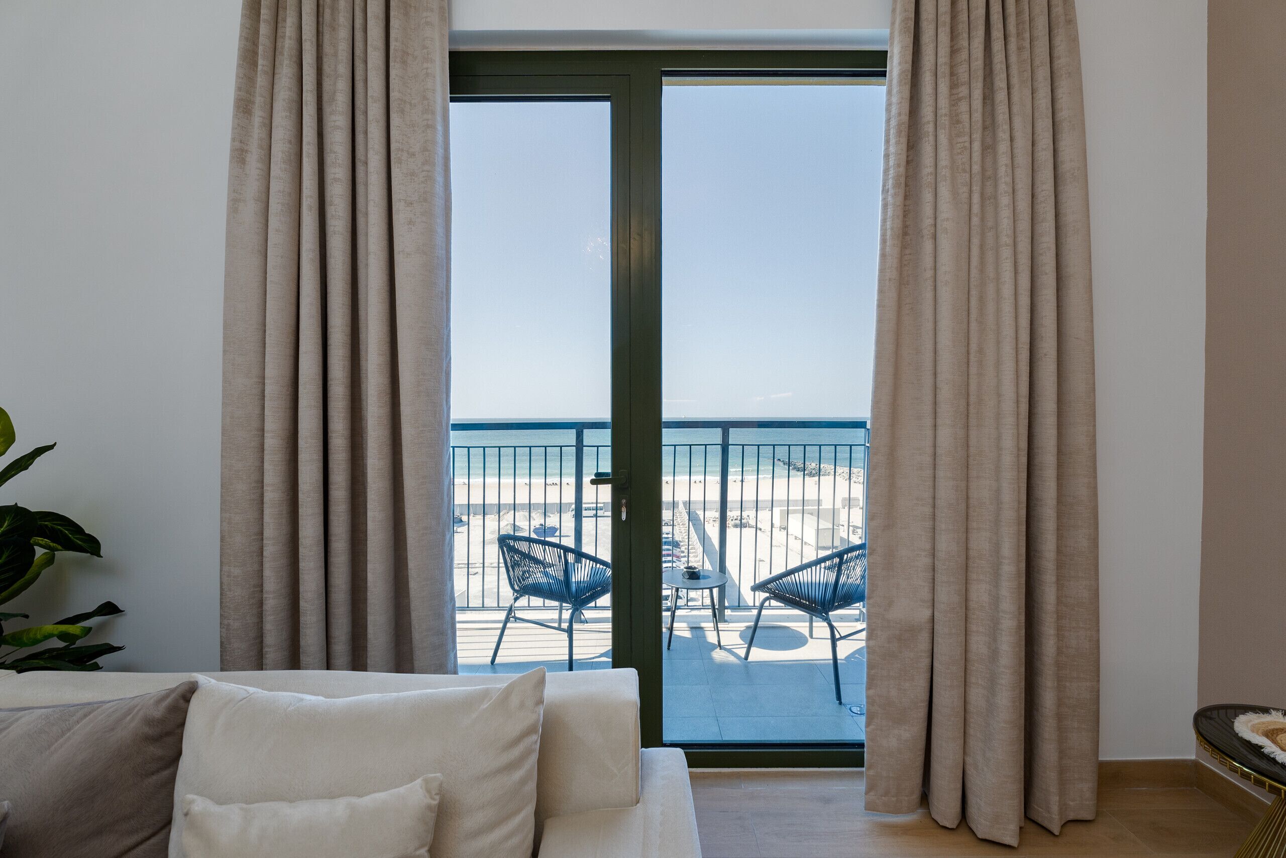 A room with a sliding glass door leading to a balcony with outdoor seating.