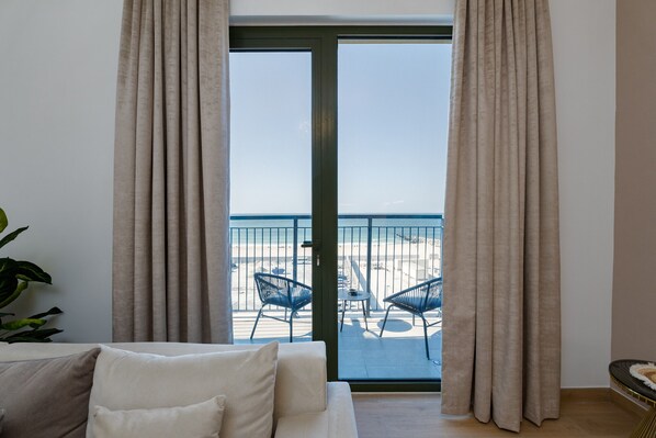 A room with a sliding glass door leading to a balcony with outdoor seating.