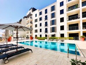 Un hôtel moderne doté d’une piscine, d’un espace extérieur aménagé et de balcons.