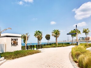 A paved pathway leading to a building with a sign reading "PORT a la MER".