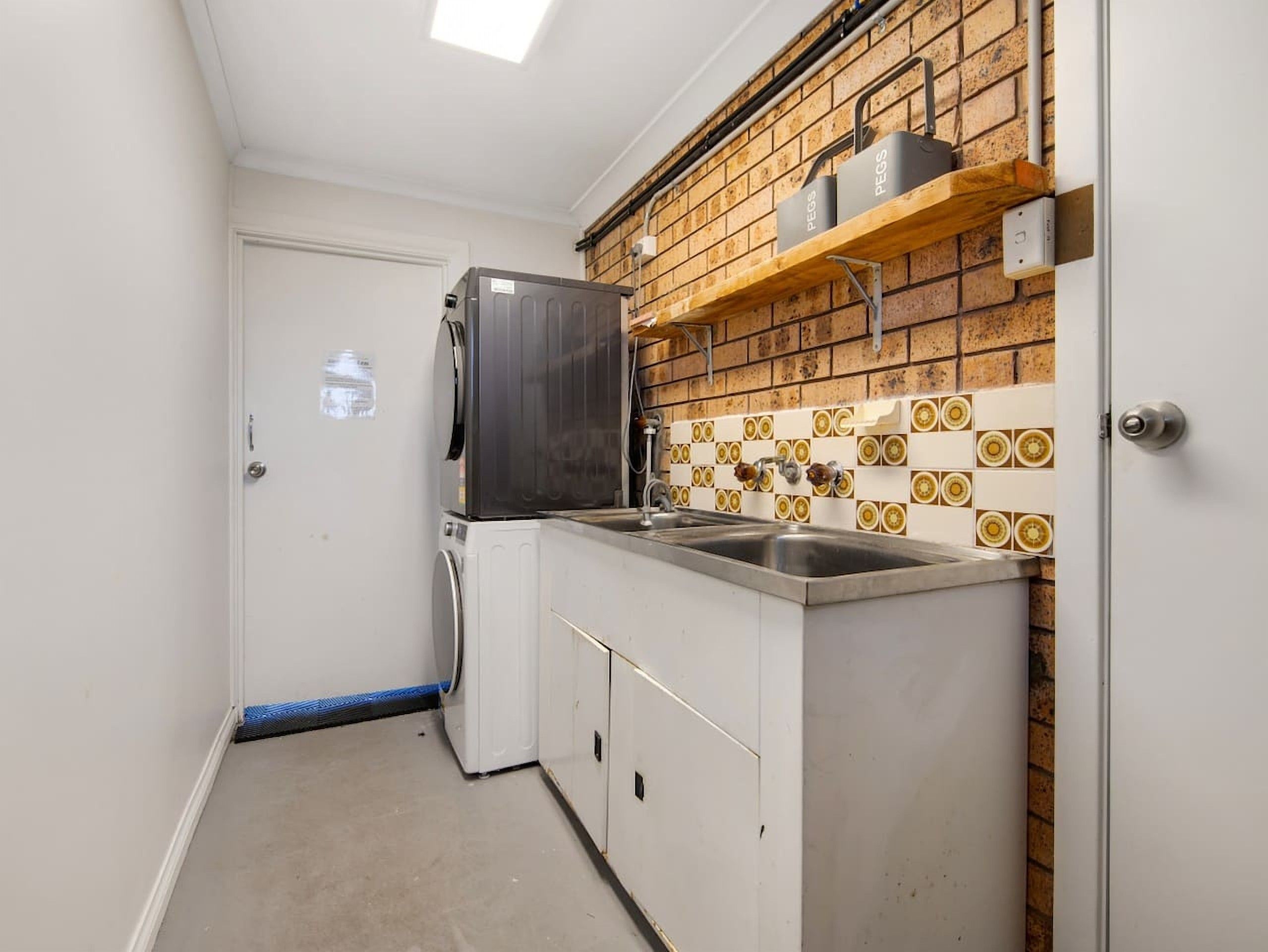 Una cocina compacta con refrigerador integrado, lavamanos y salpicadero de azulejos.