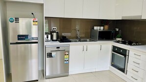 Une cuisine moderne avec des armoires blanches, des appareils en acier inoxydable et un lave-vaisselle.
