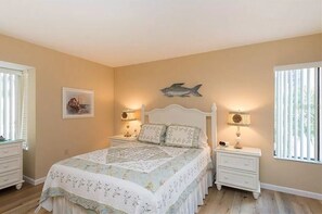 Classic bedroom with a large bed, bedside tables, and a framed picture.