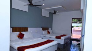 A hotel room with two beds, a ceiling fan, and a view of the outside. - Prakash Residence (Puducherry)
