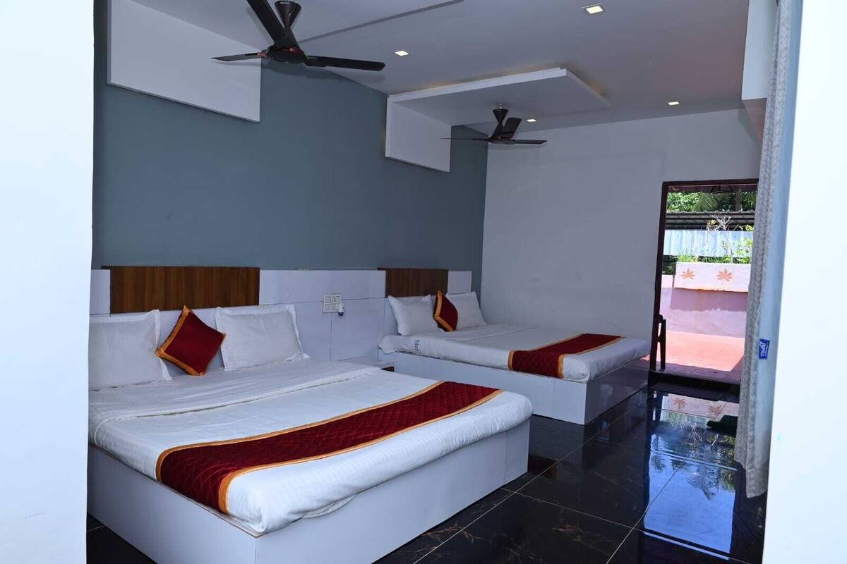A hotel room with two beds, a ceiling fan, and a view of the outside.