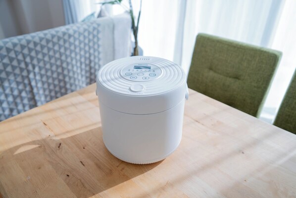 A white portable speaker on a wooden table. - Sapporo irios cozy inn (Sapporo)
