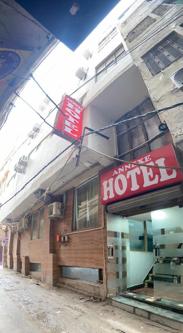 A hotel with a red sign reading "ANNEX HOTEL" and a visible entrance. - Hotel Annexe  (New Delhi)