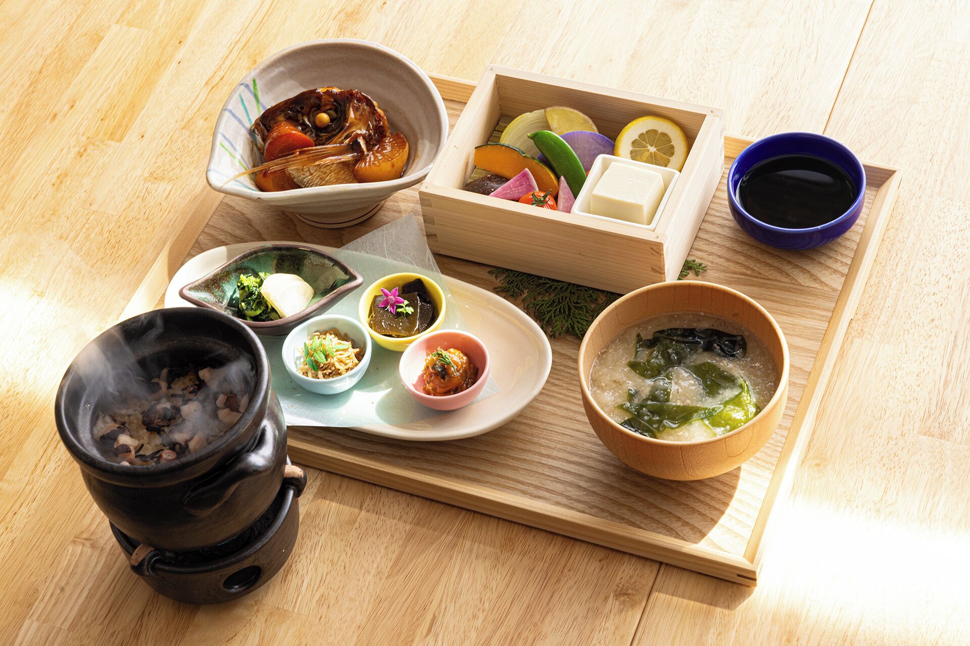 Een traditionele Japanse maaltijdopstelling met verschillende gerechten en een theepot.
