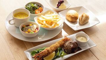 A variety of dishes including seafood, fries, and bread, served on white plates and bowls.