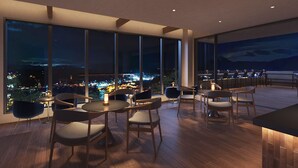A modern dining area with large windows offering a nighttime city view. - onomichi club (Onomichi)