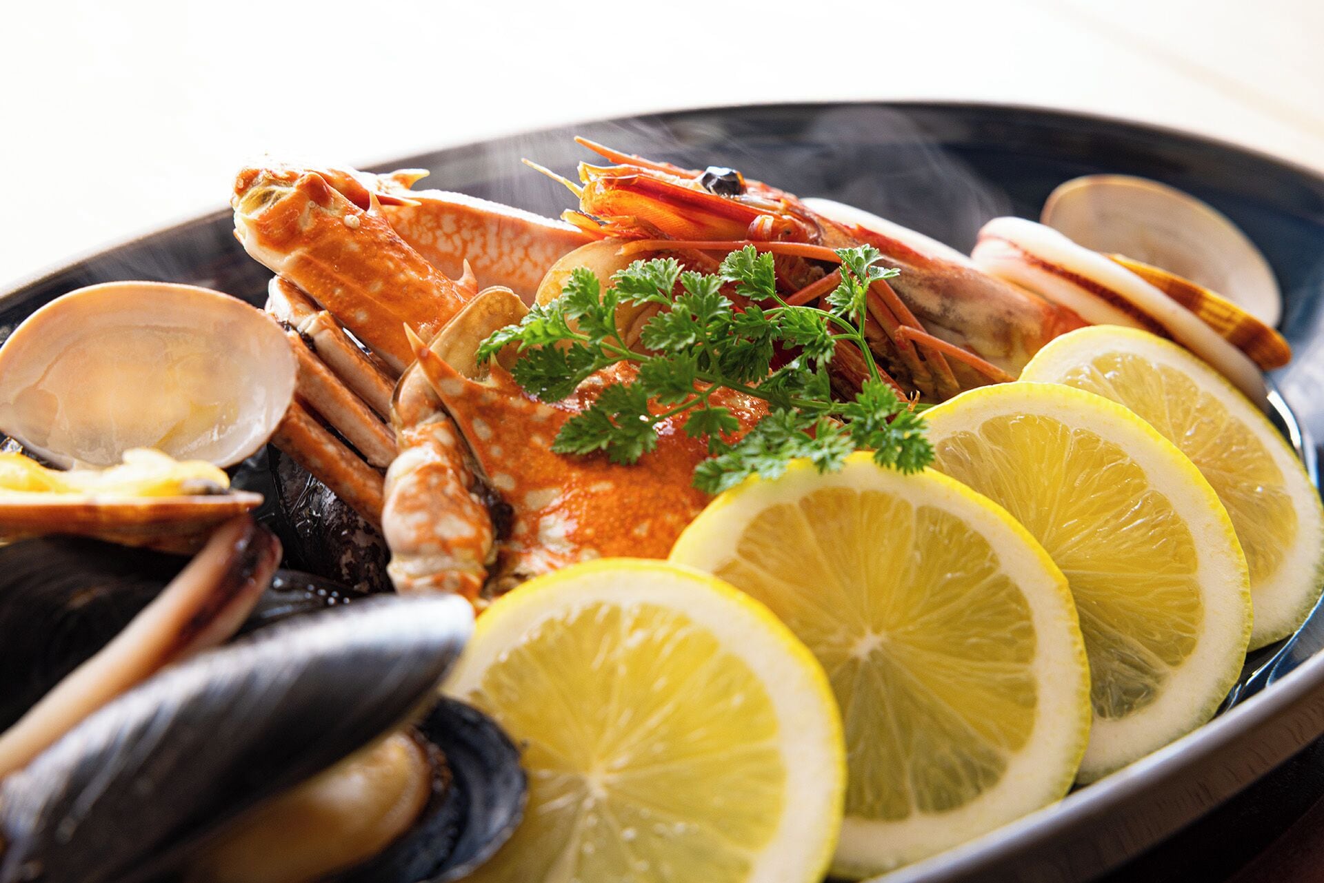 A seafood platter with shrimp, clams, and lemon slices.