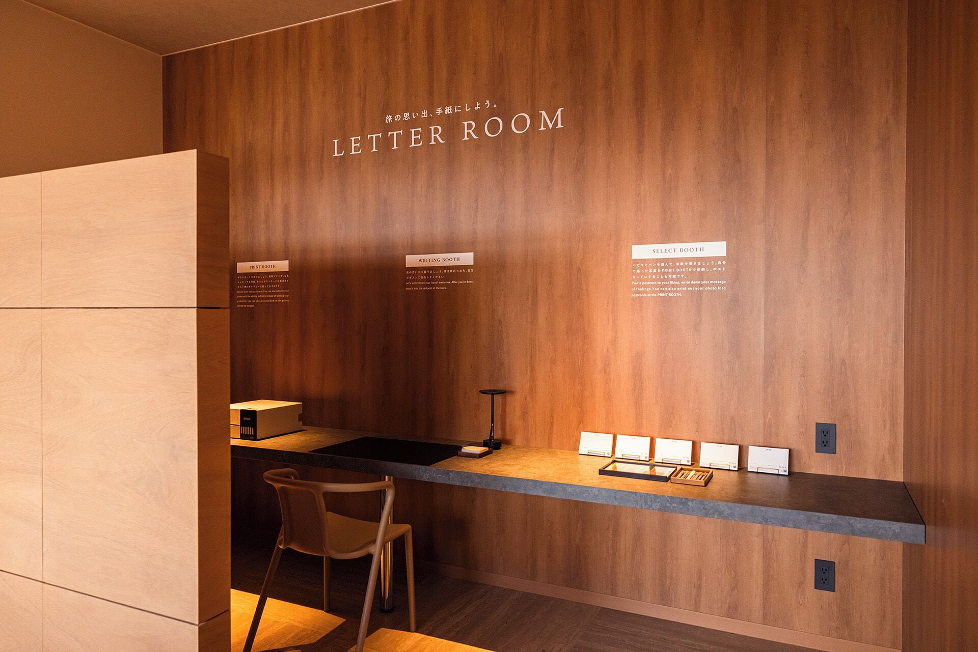 A modern letter room with a wooden wall, a print booth, a writing booth, and a select booth.